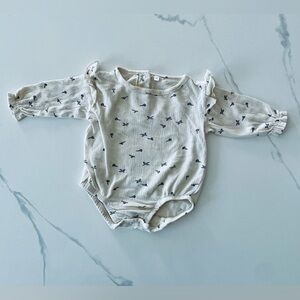Cream Baby Romper with long sleeves and prints.